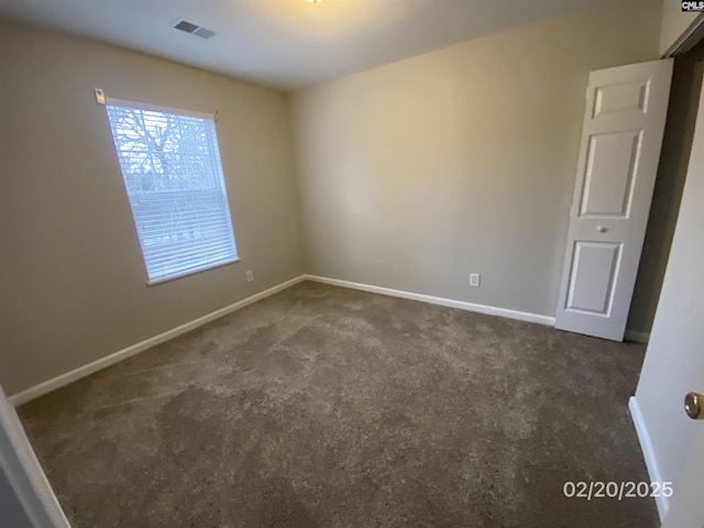 empty room featuring carpet, visible vents, and baseboards