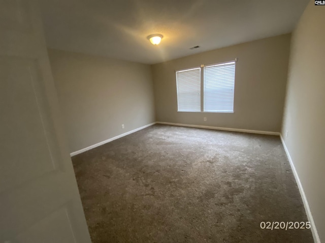 carpeted spare room featuring visible vents and baseboards