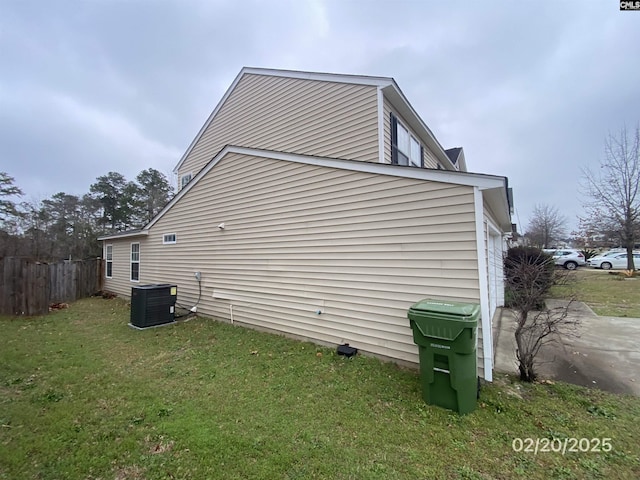 view of side of home with cooling unit, fence, and a lawn