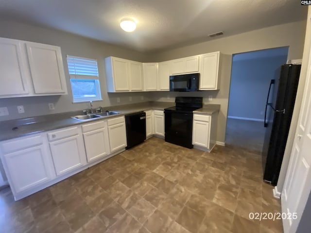 kitchen with black appliances, white cabinetry, visible vents, and a sink