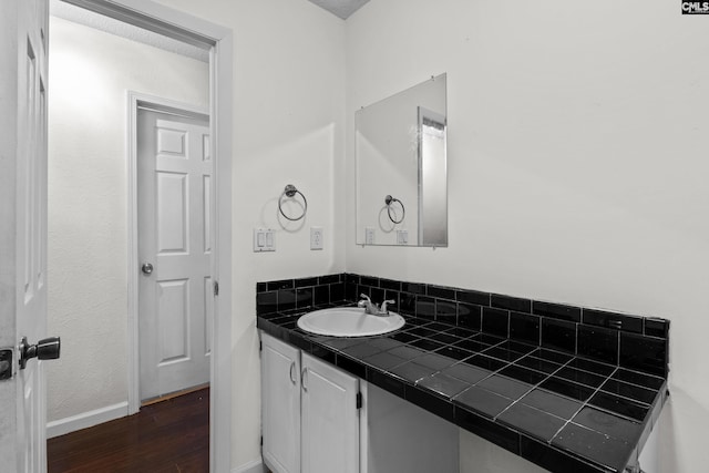 bathroom with vanity, baseboards, and wood finished floors