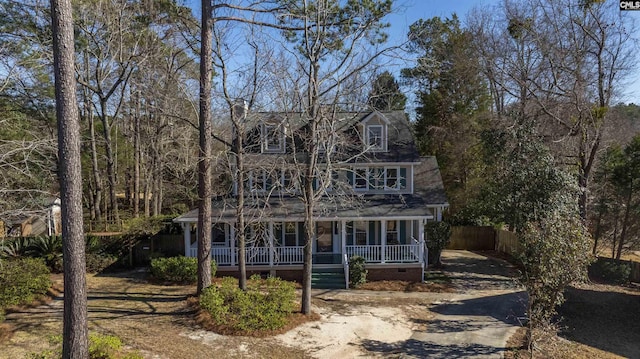 view of front of property with crawl space, covered porch, driveway, and fence