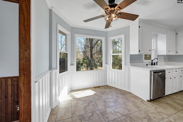 kitchen with a wainscoted wall, light countertops, white cabinets, a sink, and dishwasher