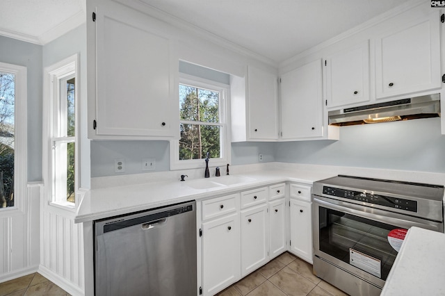 kitchen with stainless steel appliances, crown molding, light countertops, under cabinet range hood, and a sink