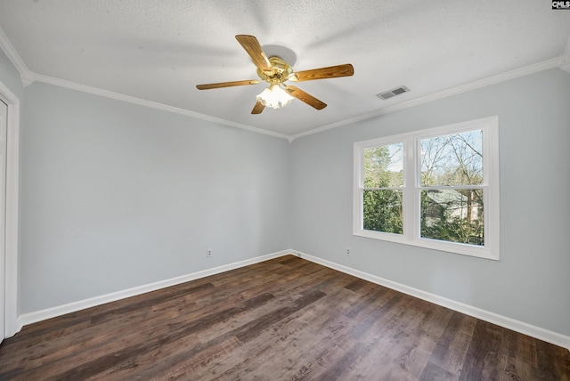 empty room featuring dark wood-style flooring, visible vents, crown molding, and baseboards