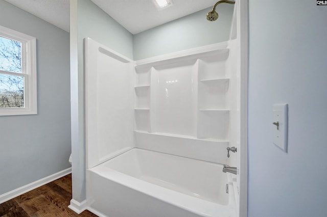 full bathroom featuring  shower combination, baseboards, and wood finished floors