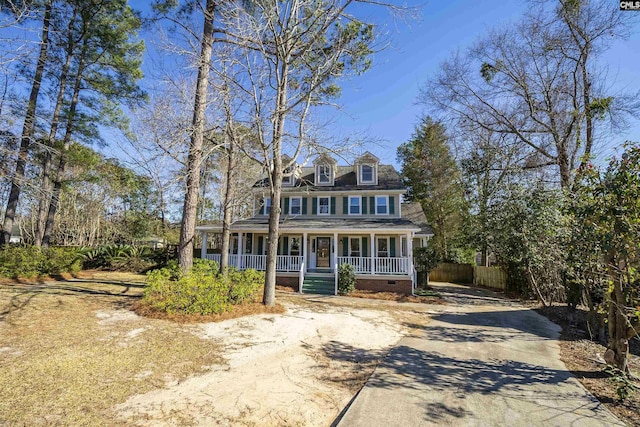 view of front facade with covered porch, driveway, and crawl space