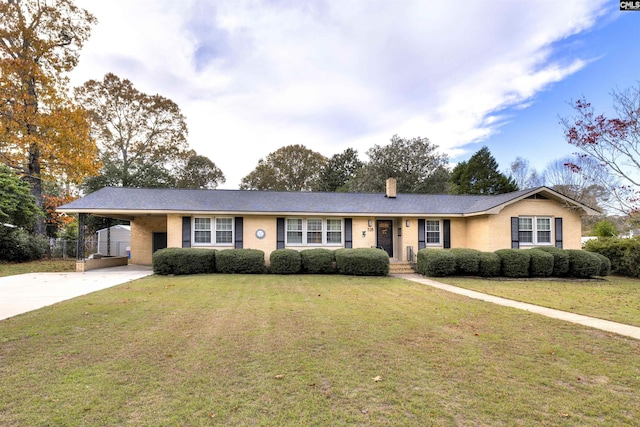 ranch-style house with concrete driveway, an attached carport, a front lawn, and a chimney