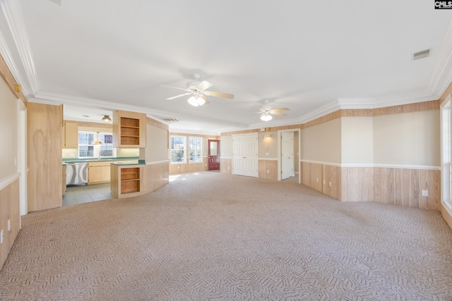 unfurnished living room featuring ornamental molding, wainscoting, and visible vents