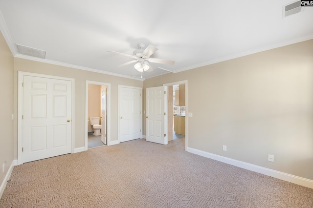 unfurnished bedroom with carpet, visible vents, baseboards, and ornamental molding