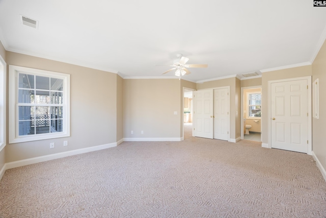 interior space with baseboards, ornamental molding, visible vents, and light colored carpet