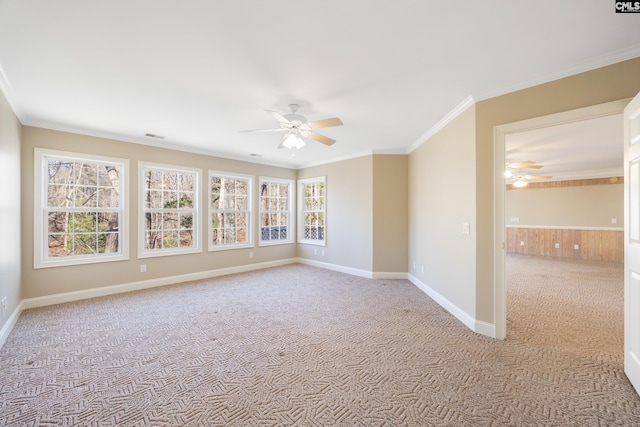 spare room with light carpet, baseboards, a ceiling fan, and crown molding