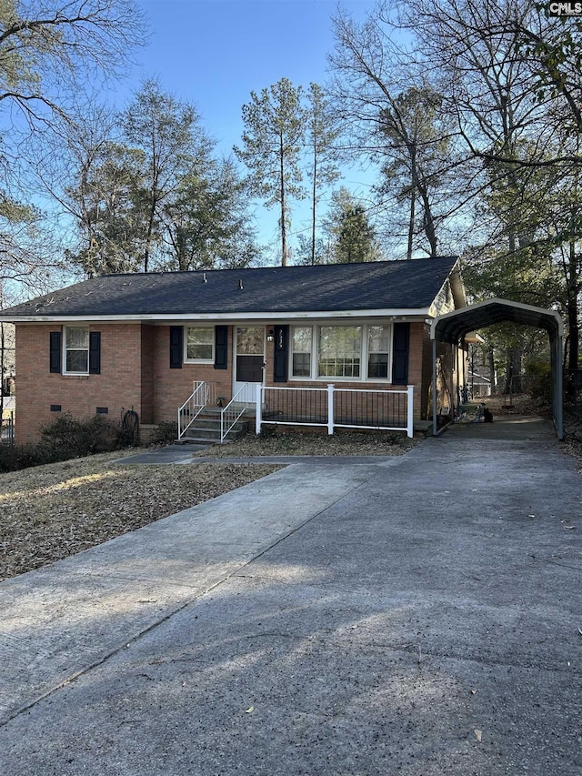 ranch-style home featuring driveway, crawl space, covered porch, a carport, and brick siding