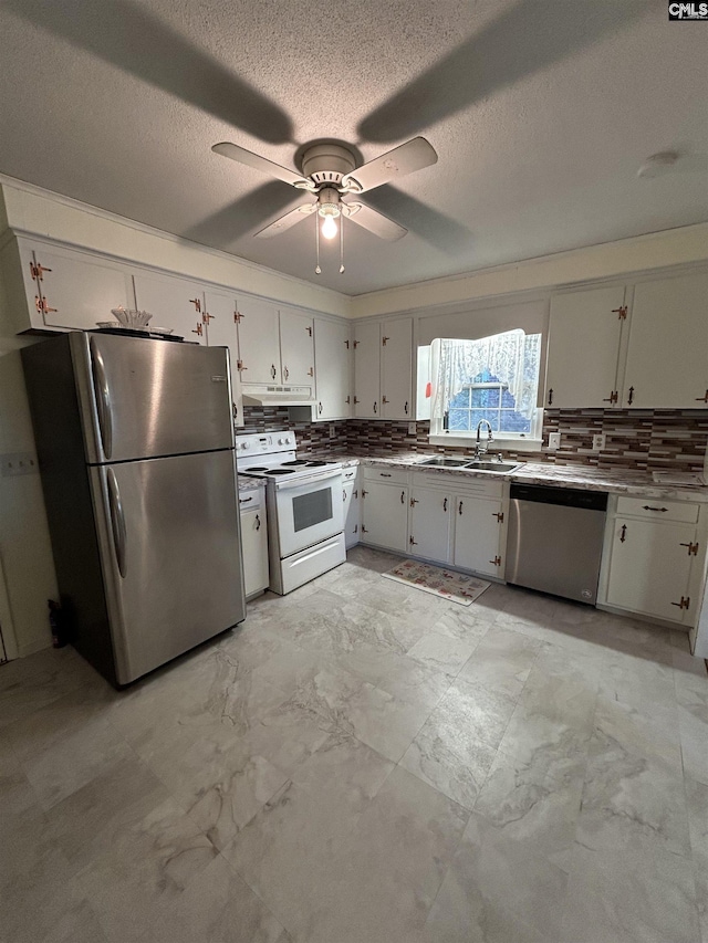 kitchen with marble finish floor, decorative backsplash, appliances with stainless steel finishes, a ceiling fan, and a sink