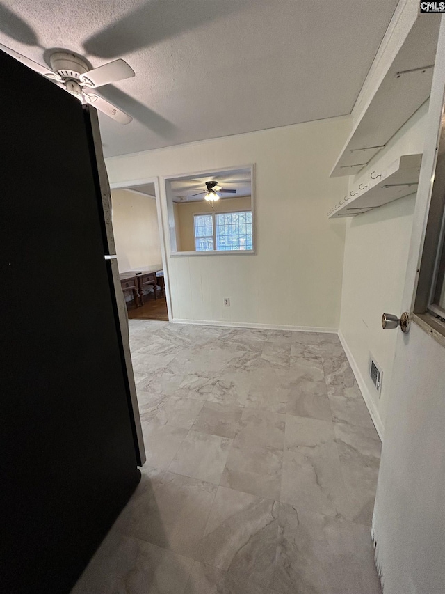 walk in closet with a ceiling fan and marble finish floor