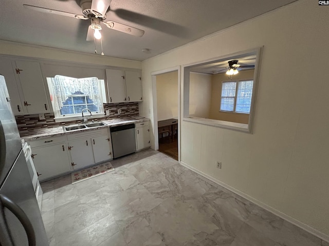 kitchen with marble finish floor, tasteful backsplash, appliances with stainless steel finishes, white cabinetry, and a sink