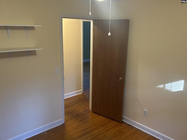 unfurnished bedroom featuring wood finished floors and baseboards