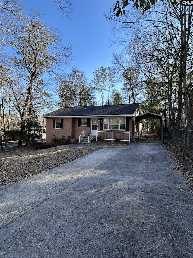 view of front of property with brick siding, fence, driveway, crawl space, and a carport