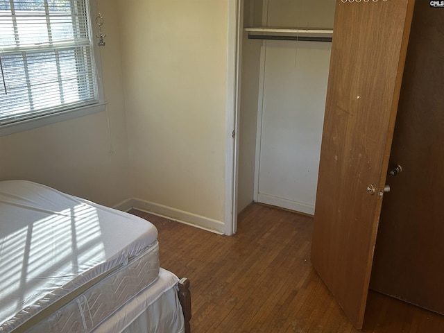 bedroom featuring a closet, wood finished floors, and baseboards