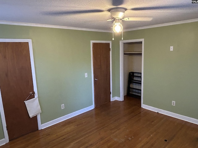 unfurnished bedroom featuring crown molding, a textured ceiling, wood finished floors, and baseboards