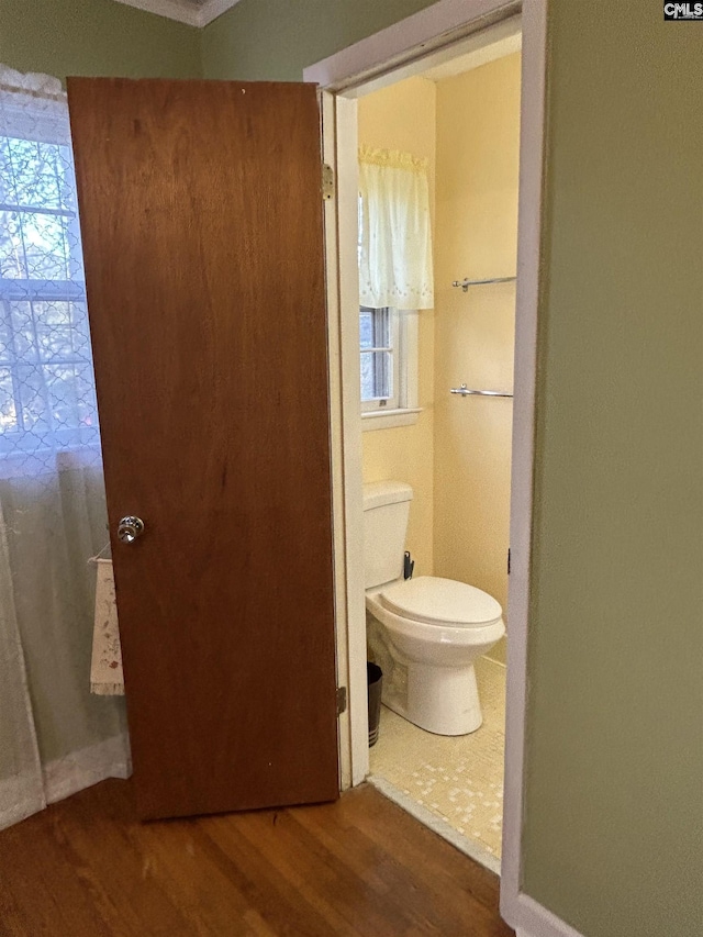 bathroom with wood finished floors, toilet, and baseboards