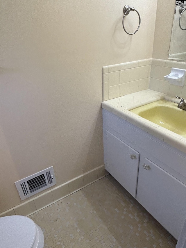 bathroom featuring visible vents, vanity, and toilet