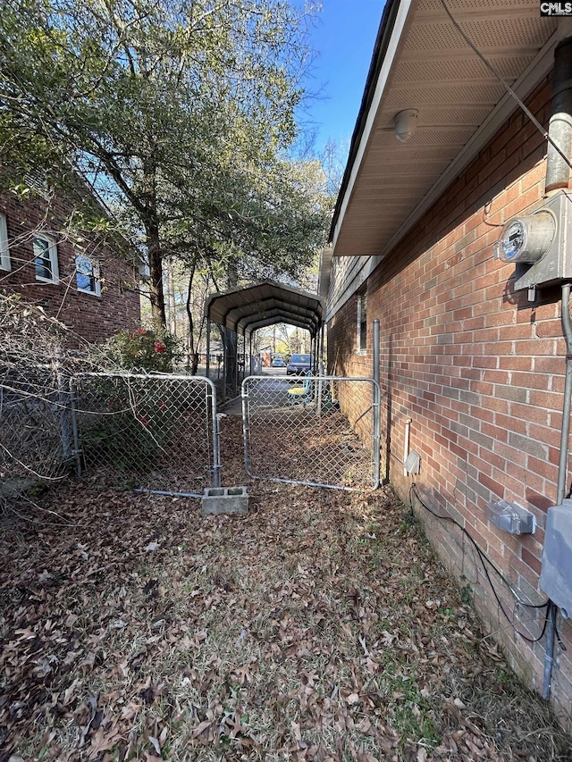 view of yard featuring a detached carport, a gate, and fence