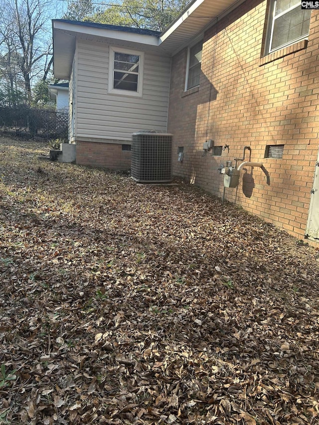 view of home's exterior with crawl space and central air condition unit