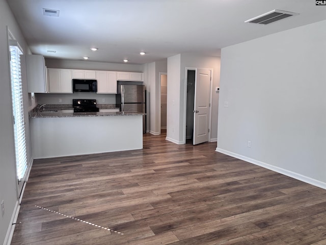 kitchen with a peninsula, visible vents, white cabinets, black appliances, and dark wood finished floors