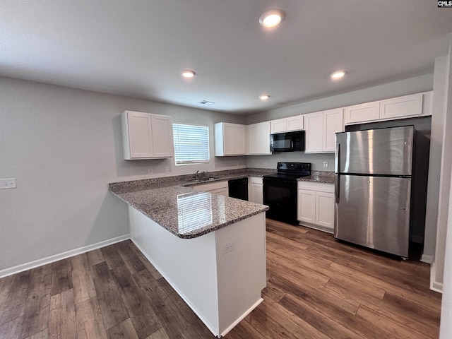 kitchen featuring white cabinets, dark stone countertops, dark wood-style flooring, a peninsula, and black appliances