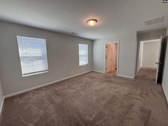 unfurnished bedroom with carpet floors, visible vents, and baseboards