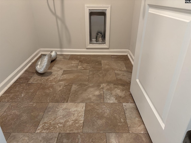 washroom with stone finish flooring, hookup for an electric dryer, baseboards, and laundry area