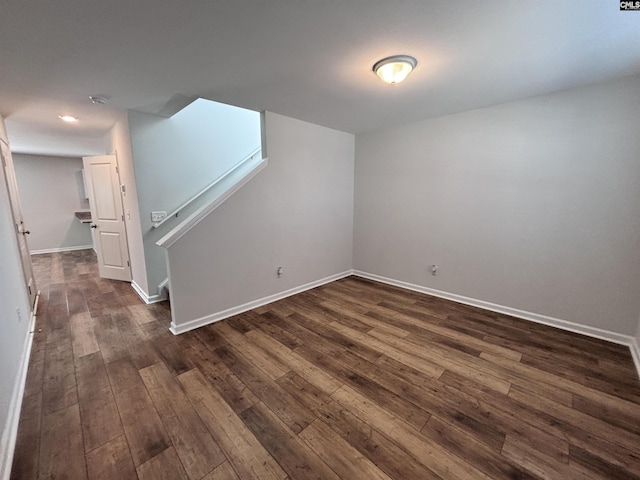 additional living space with baseboards, stairway, and dark wood finished floors