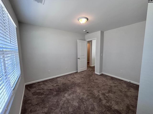 carpeted spare room featuring baseboards