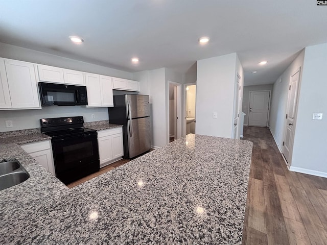 kitchen featuring white cabinets, dark wood finished floors, dark stone countertops, black appliances, and recessed lighting