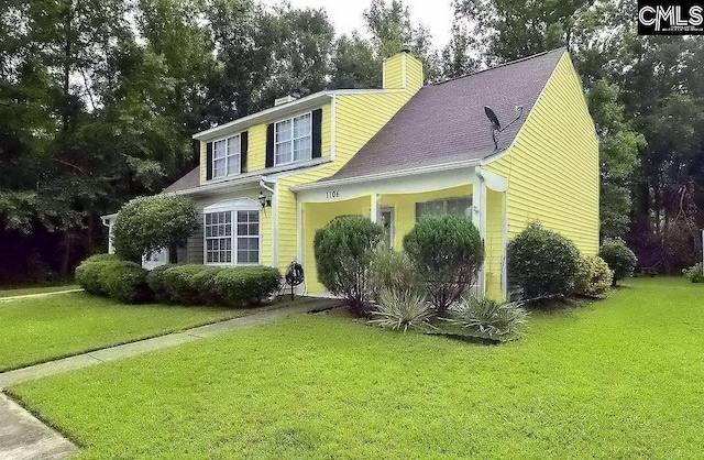 view of front facade with a chimney and a front yard