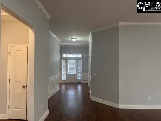 hall featuring baseboards, dark wood-type flooring, and crown molding