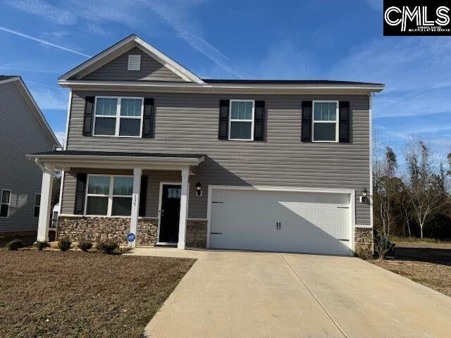 view of front facade with a garage, stone siding, and driveway