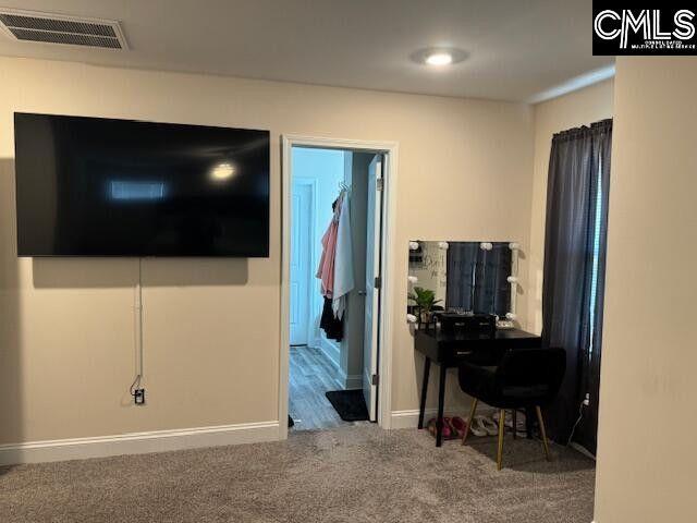 living area with carpet, visible vents, and baseboards