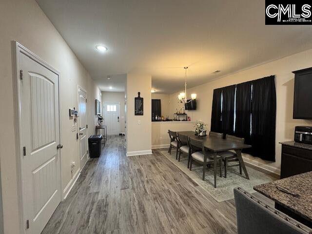 dining area with an inviting chandelier, baseboards, wood finished floors, and recessed lighting