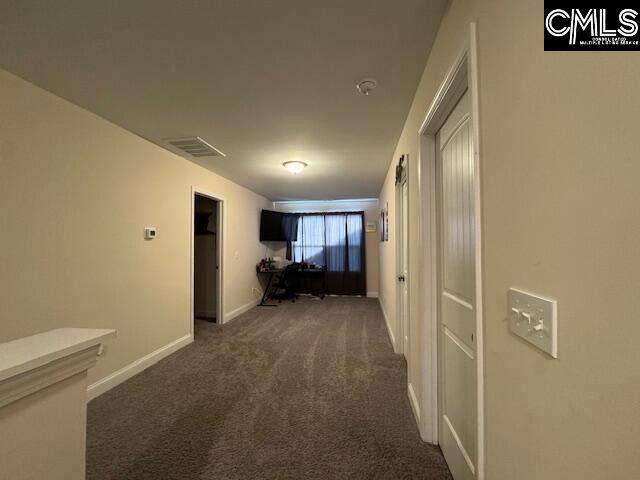 corridor featuring carpet flooring, visible vents, and baseboards