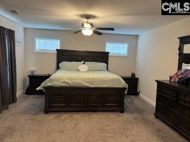 bedroom with light colored carpet, multiple windows, visible vents, and baseboards