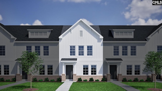 view of front of house featuring a front lawn, board and batten siding, and brick siding