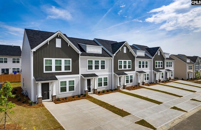 townhome / multi-family property featuring board and batten siding, a residential view, and fence