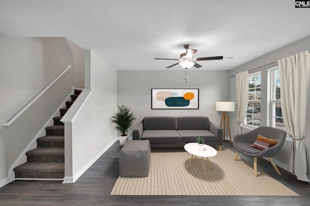 living area featuring ceiling fan, stairs, baseboards, and wood finished floors