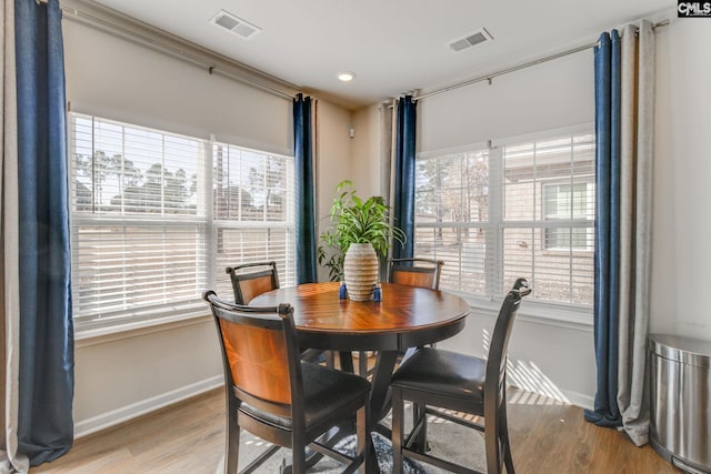 dining area with wood finished floors, visible vents, and baseboards