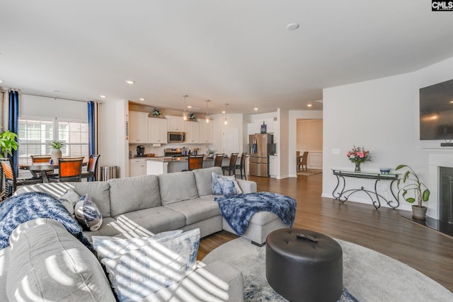 living room featuring dark wood-style floors, recessed lighting, a fireplace, and baseboards