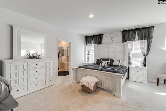 bedroom with ensuite bathroom, recessed lighting, light colored carpet, visible vents, and baseboards