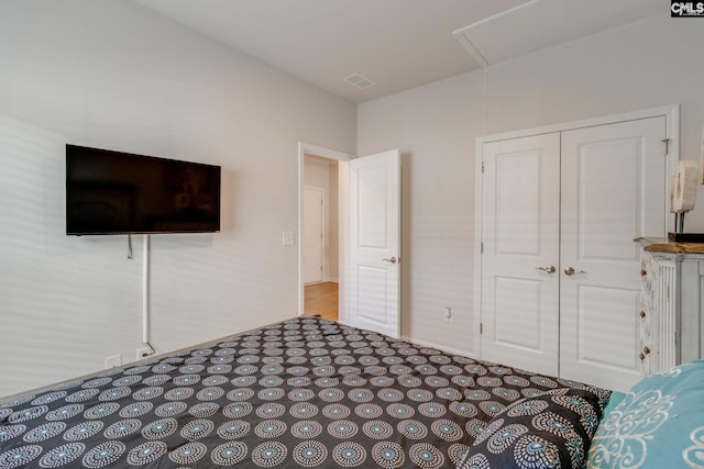 unfurnished bedroom featuring visible vents, a closet, and attic access