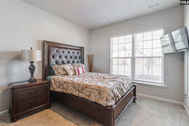 bedroom with visible vents, light carpet, and baseboards